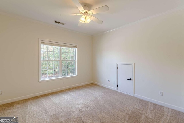 carpeted empty room with ceiling fan and ornamental molding