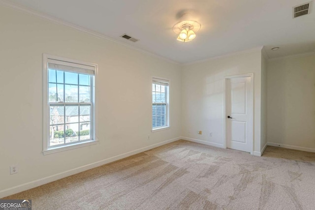 empty room with light colored carpet and crown molding