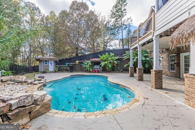 view of swimming pool with a patio and a shed