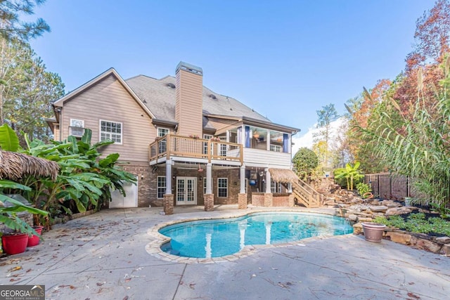 view of swimming pool featuring a sunroom, french doors, a patio, and a deck