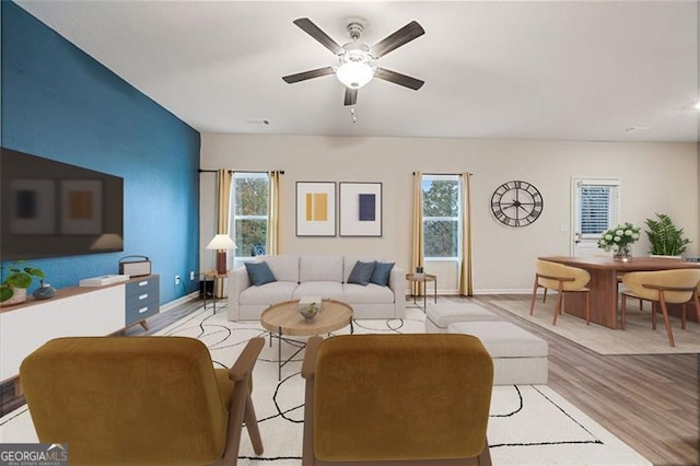 living room featuring ceiling fan, a wealth of natural light, and light hardwood / wood-style flooring