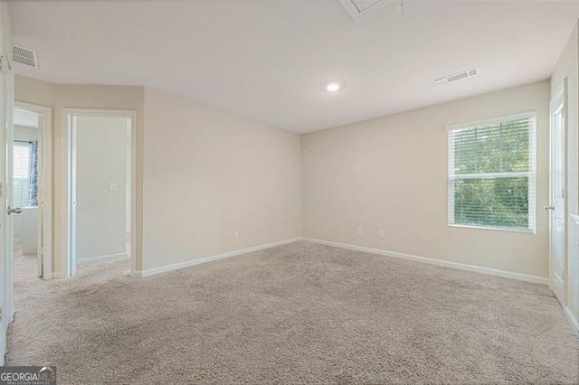 empty room featuring light colored carpet and a healthy amount of sunlight