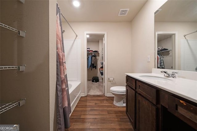 full bathroom featuring shower / bathtub combination with curtain, hardwood / wood-style floors, vanity, and toilet