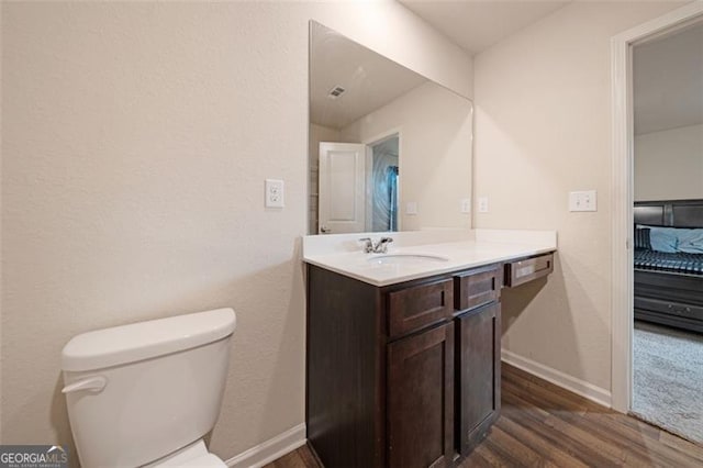 bathroom featuring hardwood / wood-style floors, vanity, and toilet