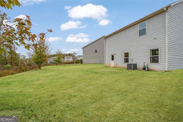 rear view of property with a yard and central AC unit