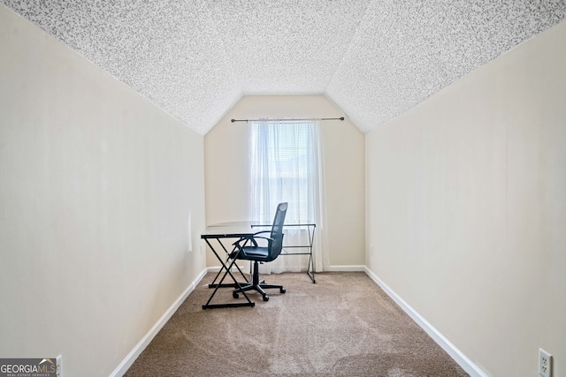 carpeted office featuring a textured ceiling and vaulted ceiling