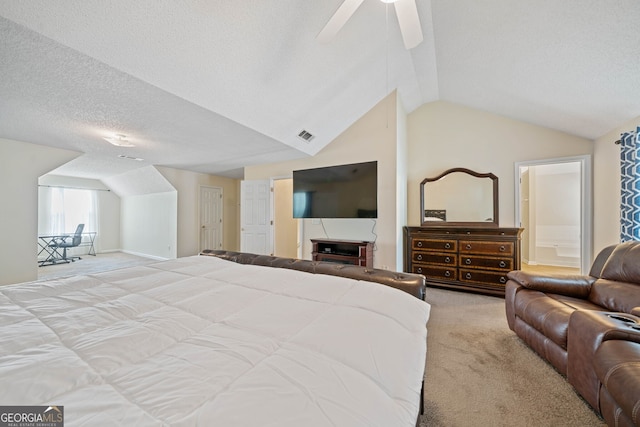 bedroom featuring lofted ceiling, light carpet, ceiling fan, a textured ceiling, and connected bathroom