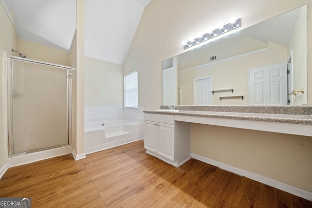 bathroom with wood-type flooring, vanity, shower with separate bathtub, and vaulted ceiling