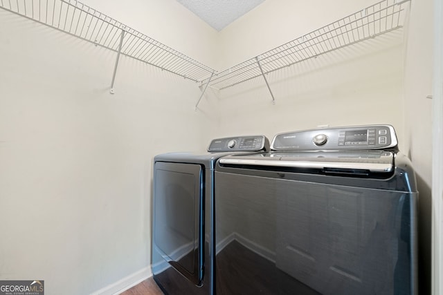 clothes washing area featuring hardwood / wood-style floors and washing machine and dryer