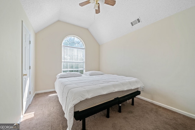 bedroom with a textured ceiling, ceiling fan, carpet, and vaulted ceiling