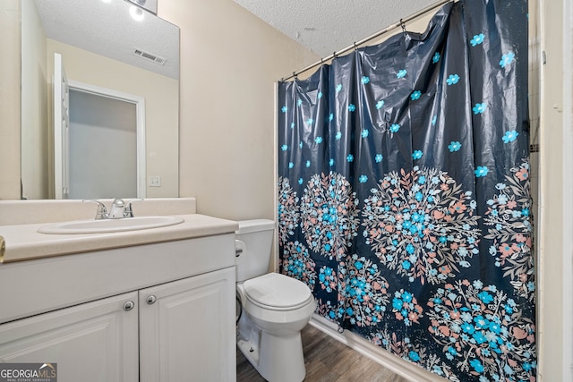 bathroom with vanity, hardwood / wood-style floors, a textured ceiling, and toilet