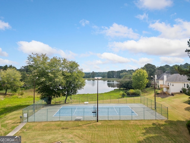 exterior space with a lawn, a water view, and tennis court