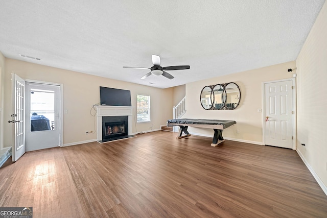 rec room with ceiling fan, wood-type flooring, and a textured ceiling