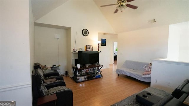 living room with hardwood / wood-style floors, ceiling fan, and high vaulted ceiling