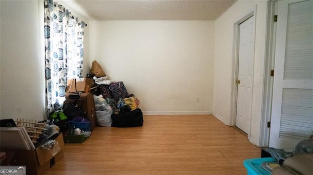 miscellaneous room featuring a textured ceiling and light hardwood / wood-style flooring