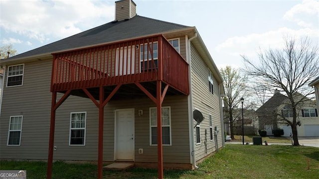 rear view of house with a yard and a wooden deck