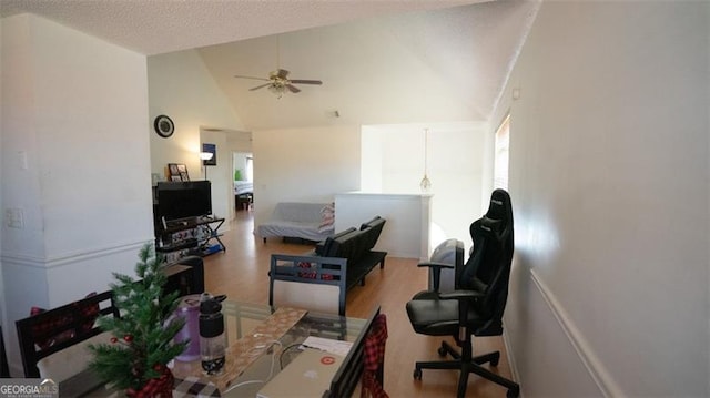 interior space with a wealth of natural light, a textured ceiling, ceiling fan, high vaulted ceiling, and hardwood / wood-style floors