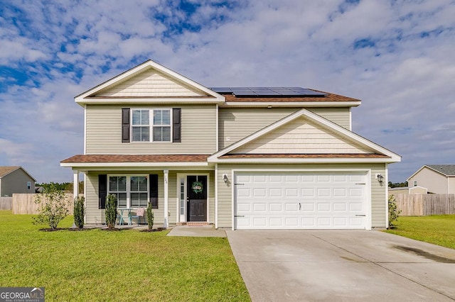 traditional home with roof mounted solar panels, driveway, a front lawn, and fence