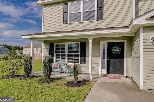 property entrance with a porch and a yard