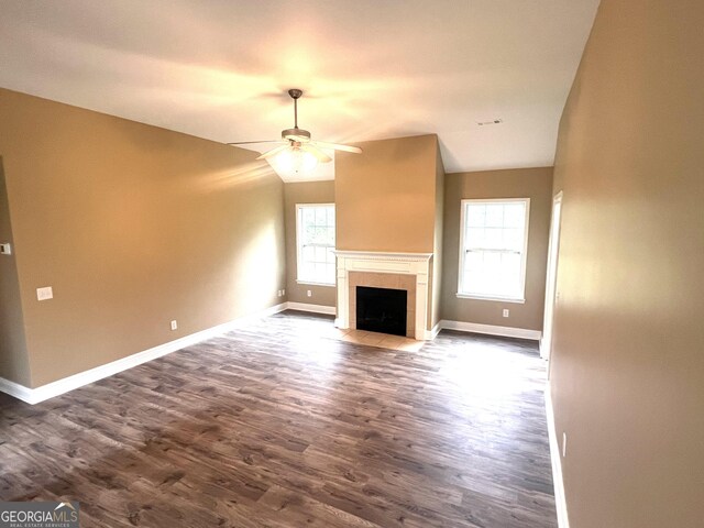 unfurnished living room featuring ceiling fan, dark hardwood / wood-style flooring, and vaulted ceiling