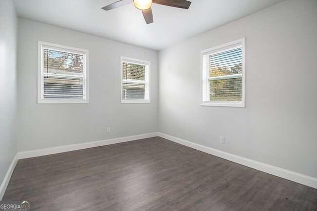 empty room featuring ceiling fan and dark wood-type flooring