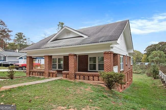 bungalow-style home with a front lawn and covered porch