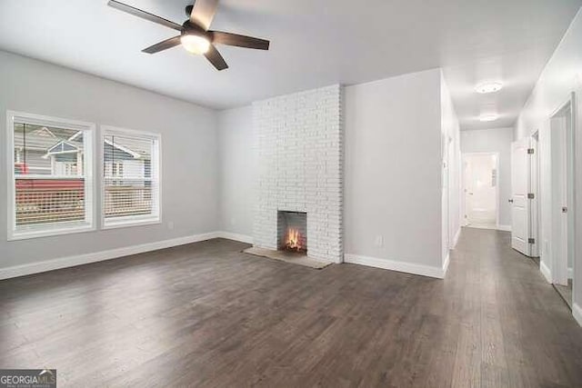 unfurnished living room with a fireplace, dark hardwood / wood-style flooring, and ceiling fan