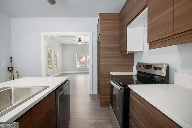 kitchen with stainless steel appliances, ceiling fan, dark wood-type flooring, and sink