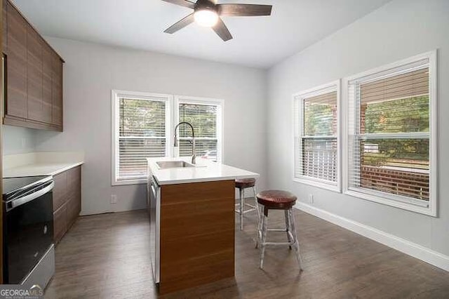 kitchen with ceiling fan, sink, a center island with sink, dark hardwood / wood-style floors, and black range with electric stovetop