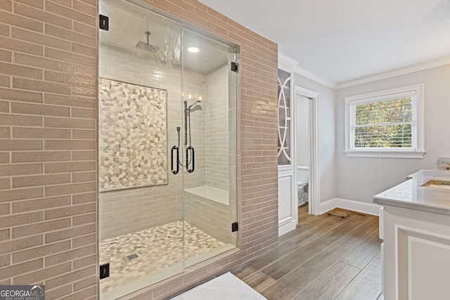 bathroom featuring vanity, wood-type flooring, crown molding, and walk in shower