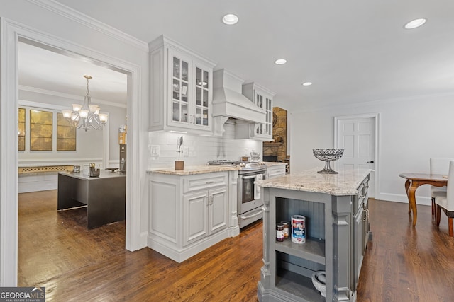 kitchen featuring gas range, white cabinetry, dark hardwood / wood-style floors, a kitchen island, and custom range hood