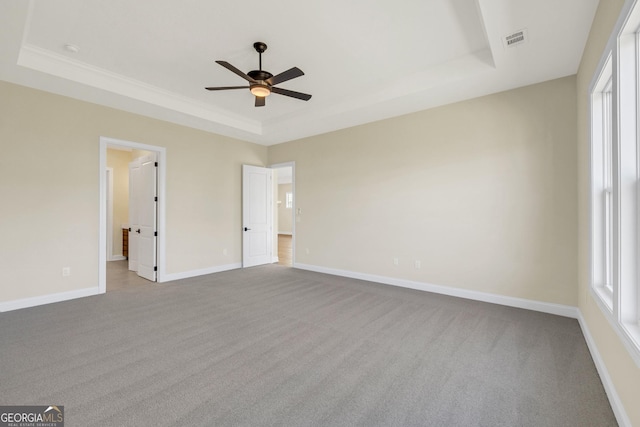 unfurnished bedroom with light colored carpet, a raised ceiling, ceiling fan, and crown molding