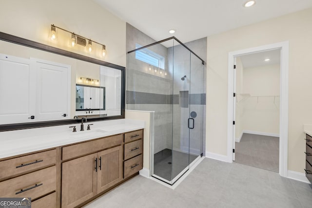 bathroom featuring tile patterned flooring, vanity, and walk in shower