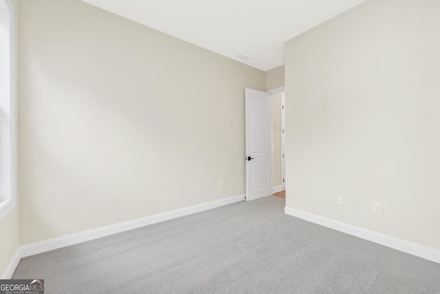 unfurnished room featuring light carpet