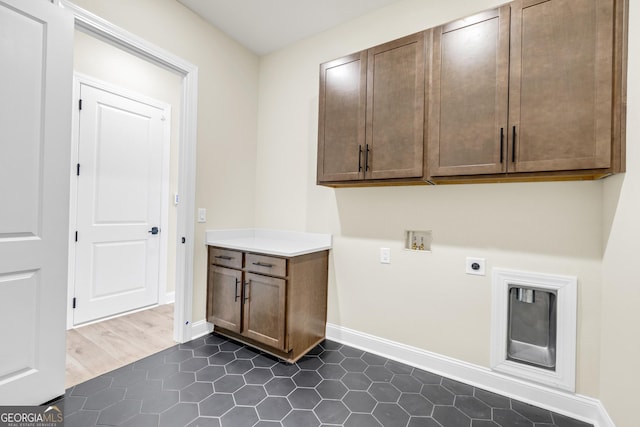 laundry area featuring hookup for an electric dryer, hookup for a washing machine, dark hardwood / wood-style floors, and cabinets