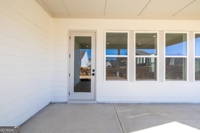 view of exterior entry featuring a patio area