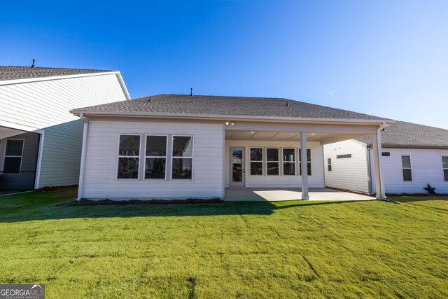 rear view of property with a lawn and a patio area