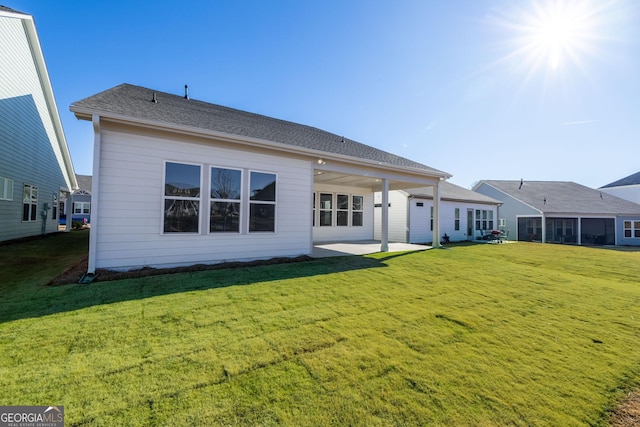 back of property with a lawn and a patio area