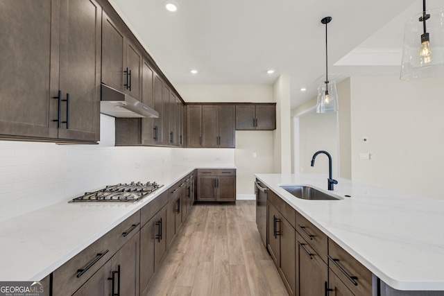 kitchen with sink, stainless steel appliances, decorative light fixtures, and light wood-type flooring