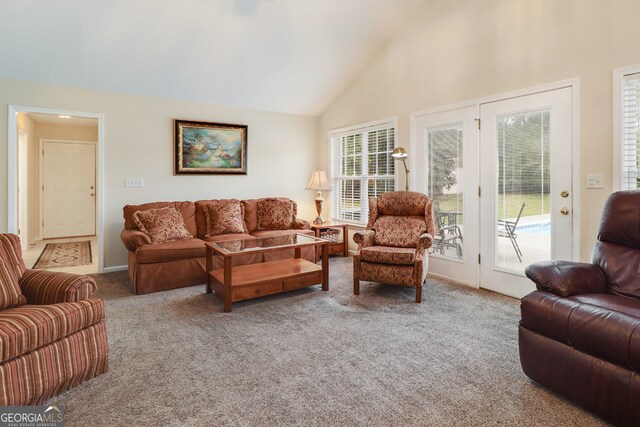 carpeted living room with plenty of natural light and high vaulted ceiling