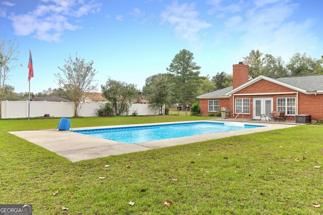 view of pool with a lawn, french doors, and a patio