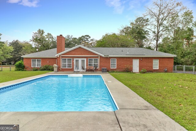 view of pool with a yard and french doors