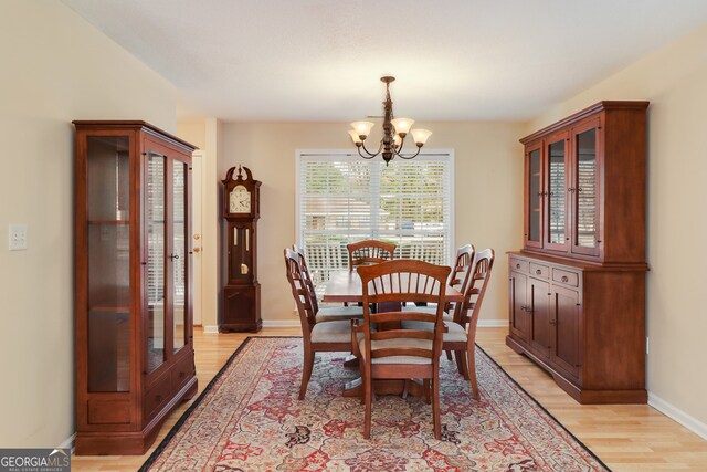 dining space featuring light hardwood / wood-style floors and an inviting chandelier