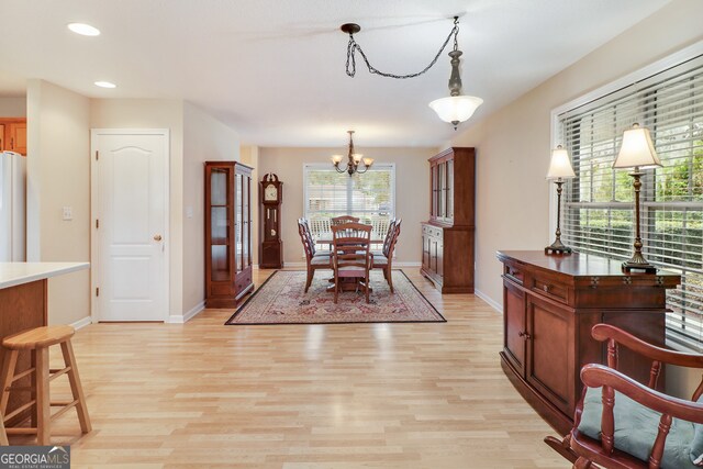 dining space with light wood-type flooring and a chandelier