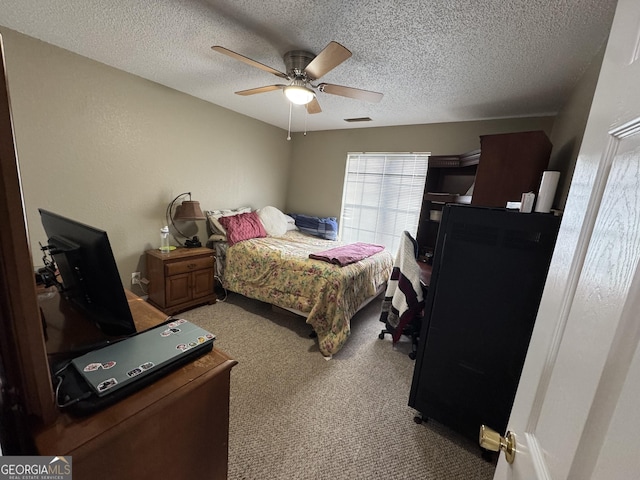 carpeted bedroom with visible vents, a textured ceiling, and ceiling fan