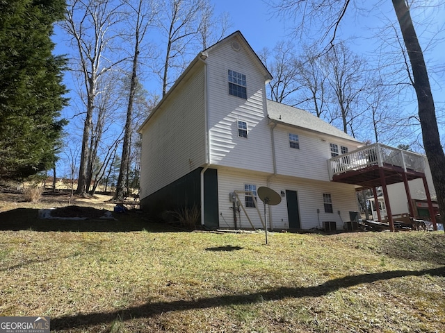 back of house featuring a yard, central AC, and a wooden deck