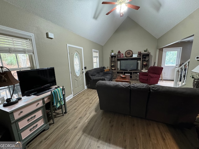 living room featuring wood-type flooring, ceiling fan, and lofted ceiling