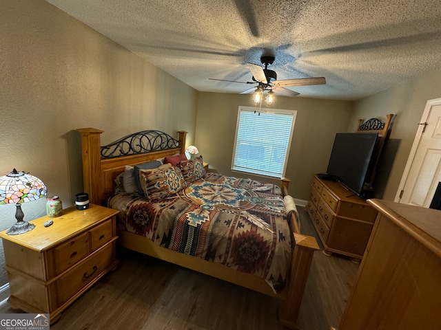 bedroom with a textured ceiling, ceiling fan, and dark wood-type flooring