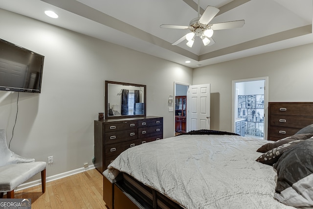 bedroom with ceiling fan, ensuite bath, and light hardwood / wood-style flooring