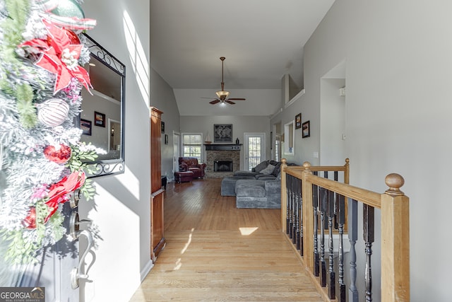 hall with lofted ceiling and light wood-type flooring